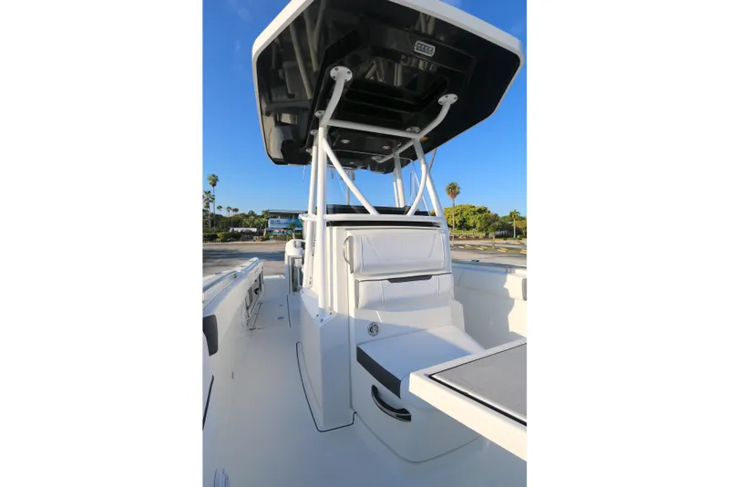 Slide: The Image of 2021 Blackfin 252 CC boat interior with seating and T-top under clear blue sky. - 6