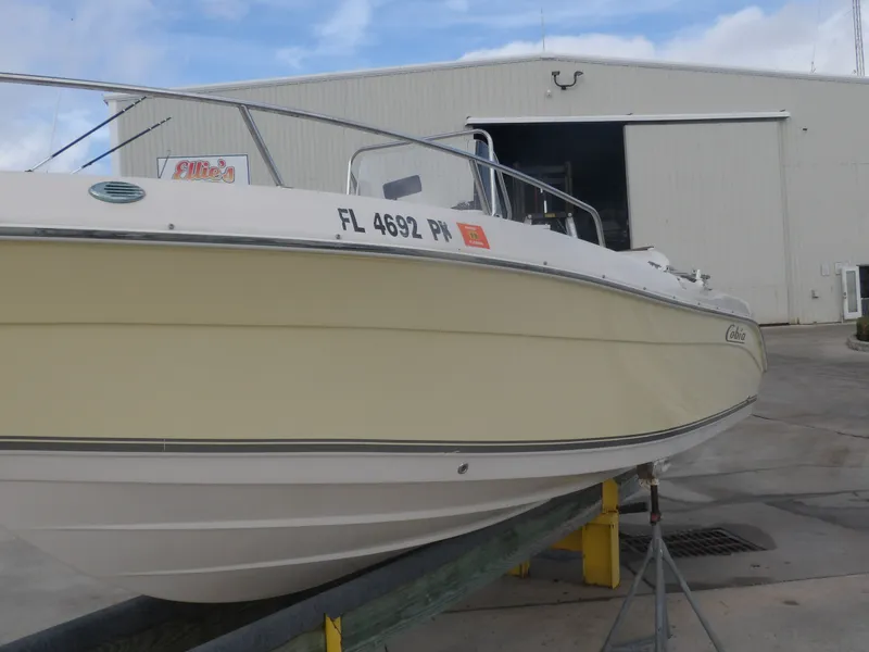 Slide: The Image of 2006 Cobia 214 Center Console boat outside warehouse. - 2