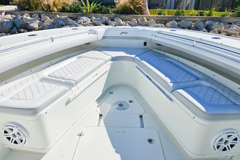 Slide: The Image of 2015 Yellowfin 42 Offshore boat interior with white cushioned seating and speakers. - 11