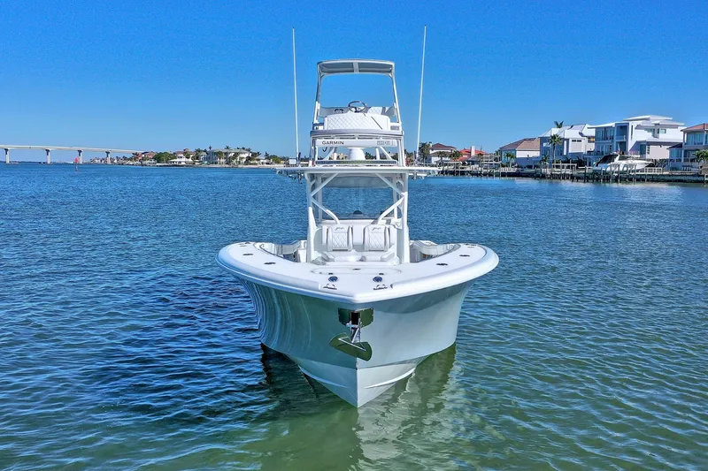 Slide: The Image of 2015 Yellowfin 42 Offshore boat on calm water near coastal homes. - 15