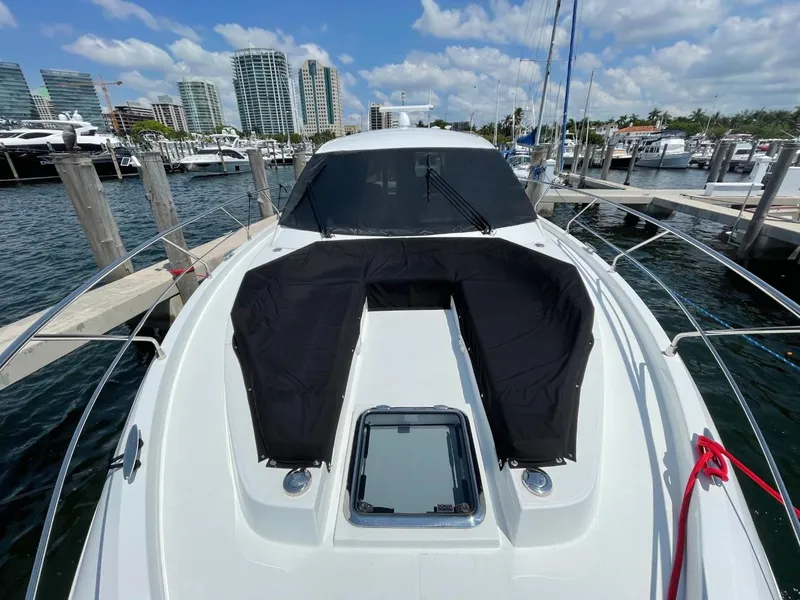 Slide: The Image of 2019 Cruisers 50 Cantius yacht docked at marina with city skyline in background. - 3