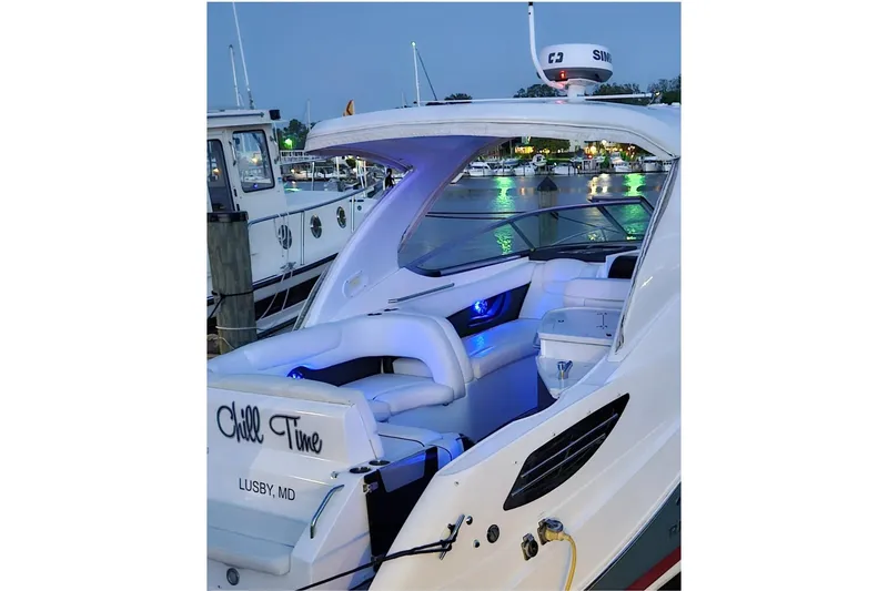 Slide: The Image of 2019 Rinker EX 290 boat docked, featuring illuminated seating and "Chill Time" text on the stern. - 3