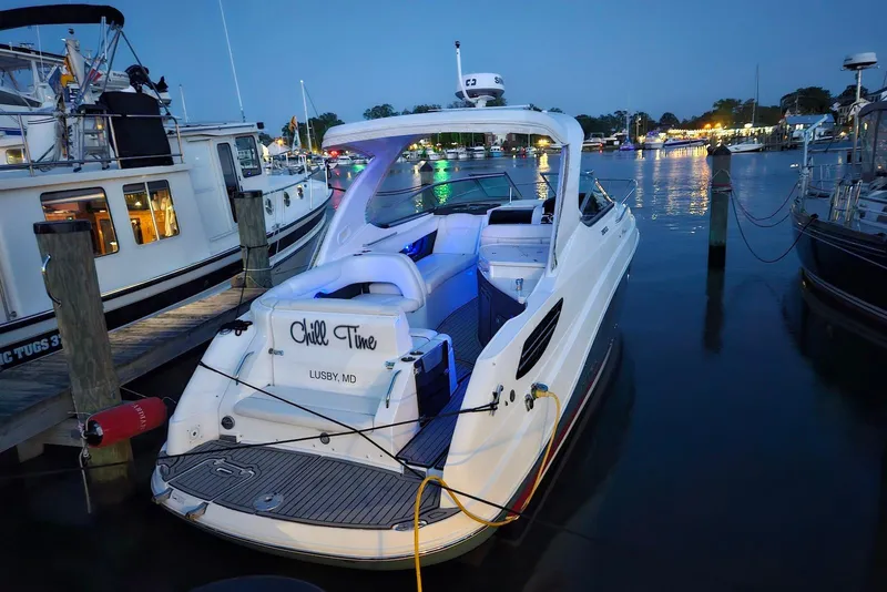 Slide: The Image of 2019 Rinker EX 290 boat docked at night, illuminated by marina lights. - 6