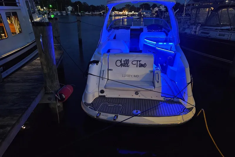 Slide: The Image of 2019 Rinker EX 290 boat docked at night with blue interior lights. - 7