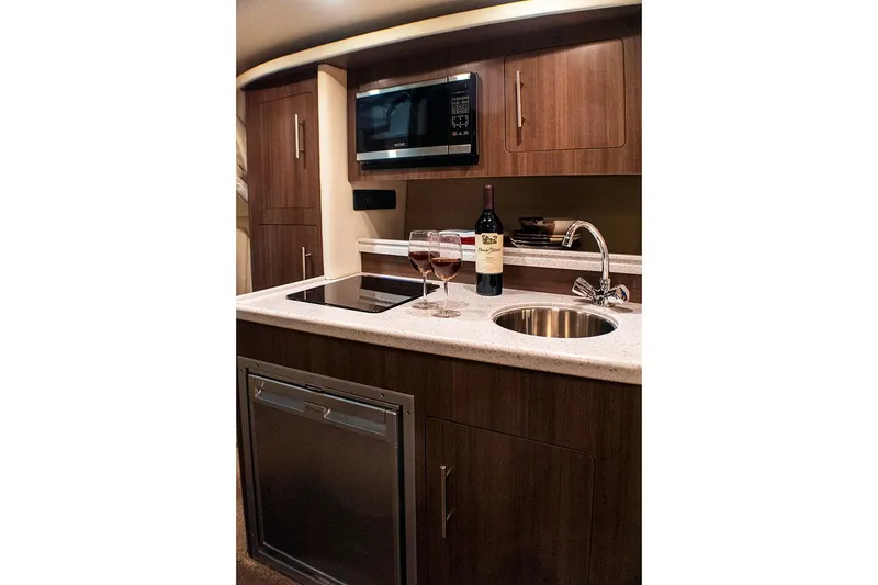 Slide: The Image of Manufacturer Provided Image: 2019 Rinker 290 EX boat kitchen with microwave, sink, and wine bottle. - 9