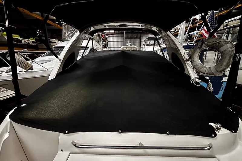 Slide: The Image of 2011 Bayliner 285 Cruiser with black cover in a storage facility. - 10