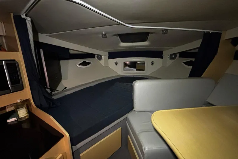 Slide: The Image of Interior of 2011 Bayliner 285 Cruiser, featuring cozy sleeping area and compact dining space. - 11