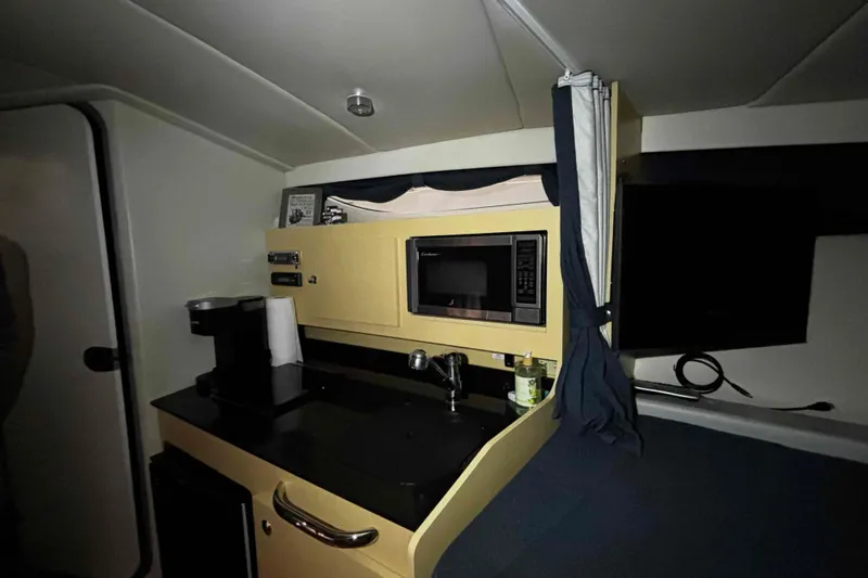 Slide: The Image of 2011 Bayliner 285 Cruiser interior with kitchenette, microwave, and sink. - 12