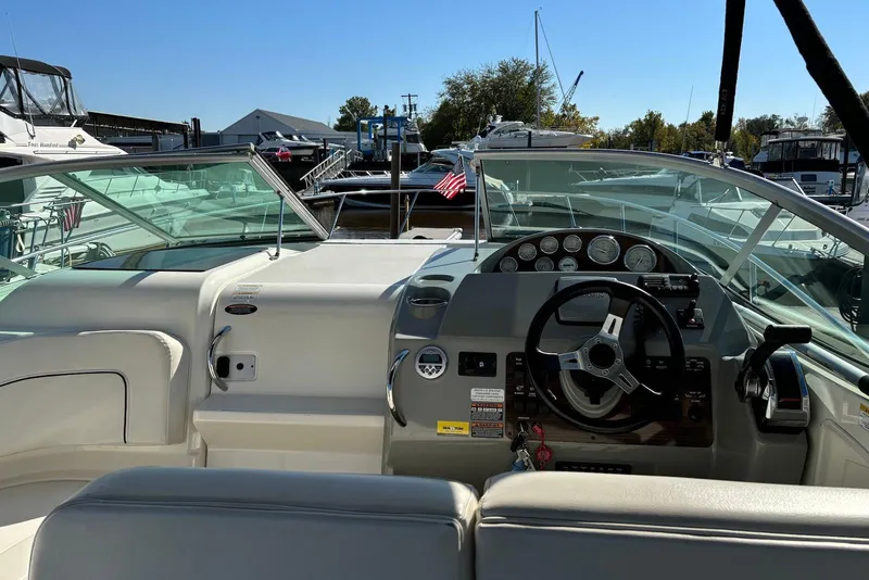 Slide: The Image of 2012 Bayliner 285 Cruiser cockpit with steering wheel and dashboard at marina. - 3