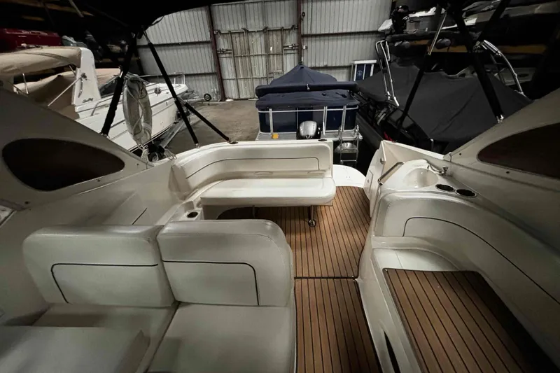 Slide: The Image of 2011 Bayliner 285 Cruiser interior with seating and wood flooring in a storage facility. - 8