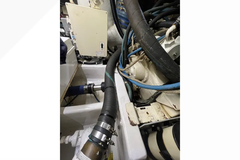 Slide: The Image of Engine compartment of a 1999 Viking 60 CPMY yacht, showing hoses and mechanical components. - 114