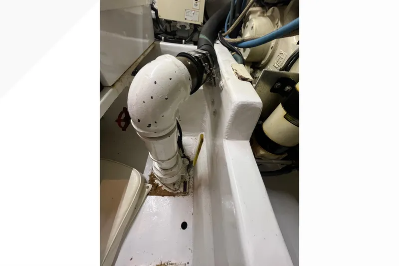 Slide: The Image of Engine room of 1999 Viking 60 CPMY yacht, featuring white piping and mechanical components. - 115