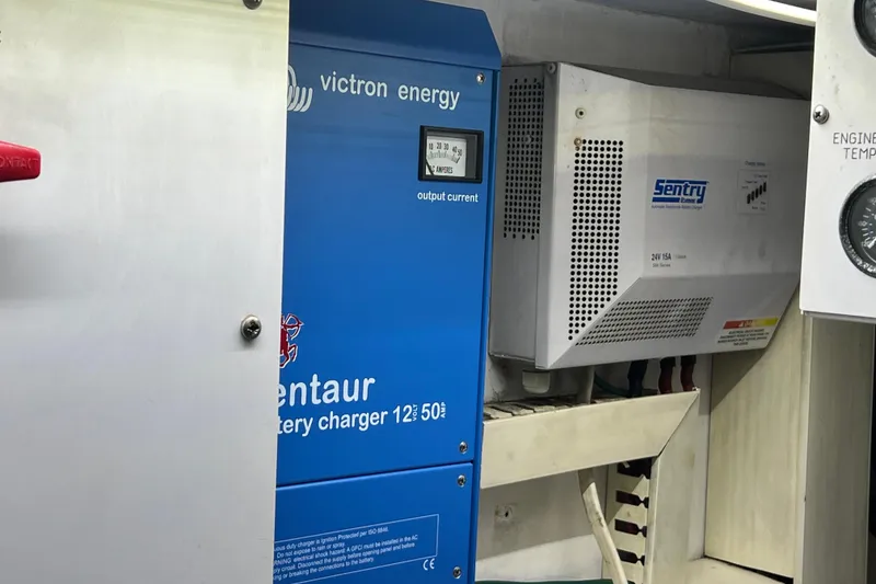 Slide: The Image of Battery chargers in a 1999 Viking 60 CPMY engine room, featuring Victron Energy and Sentry systems. - 128