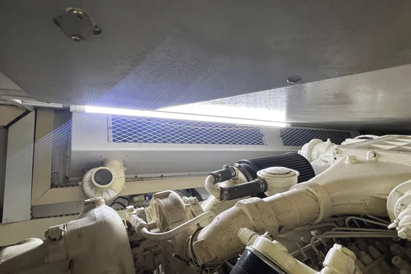 Slide: The Image of Engine room of 1999 Viking 60 CPMY yacht, featuring mechanical components and lighting. - 132