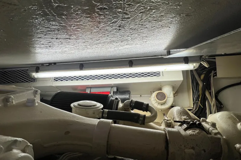 Slide: The Image of Engine room of 1999 Viking 60 CPMY yacht with visible machinery and lighting. - 134