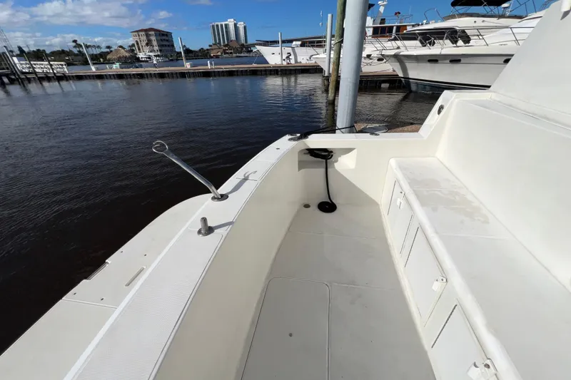 Slide: The Image of 1999 Viking 60 CPMY yacht deck with seating, docked at marina under clear sky. - 14