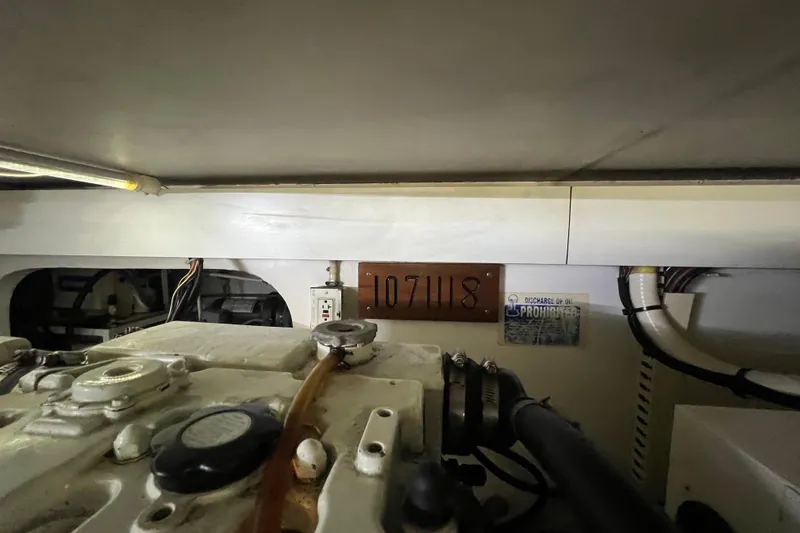 Slide: The Image of Engine room of 1999 Viking 60 CPMY yacht, showing machinery and identification plate. - 140