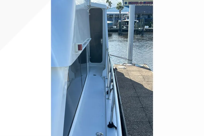 Slide: The Image of 1999 Viking 60 CPMY yacht docked, showing side deck and railing. - 24