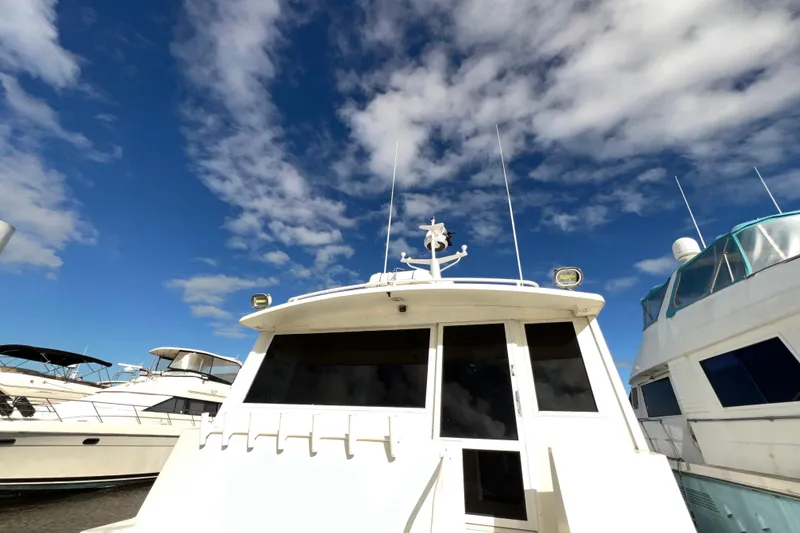 Slide: The Image of 1999 Viking 60 CPMY yacht docked under a vibrant blue sky with clouds. - 29