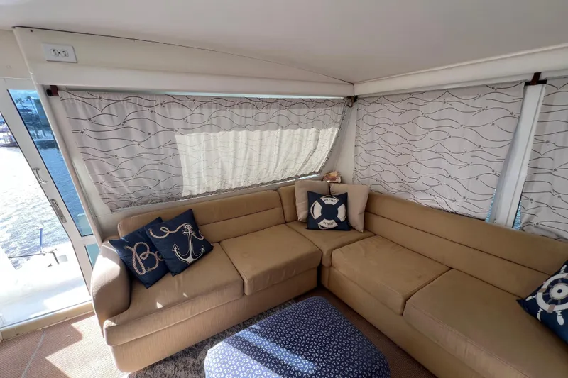 Slide: The Image of Luxurious interior of 1999 Viking 60 CPMY yacht with beige sofa and nautical-themed pillows. - 32