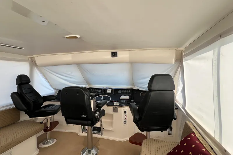 Slide: The Image of Interior helm of 1999 Viking 60 CPMY yacht with black captain chairs and navigation controls. - 38