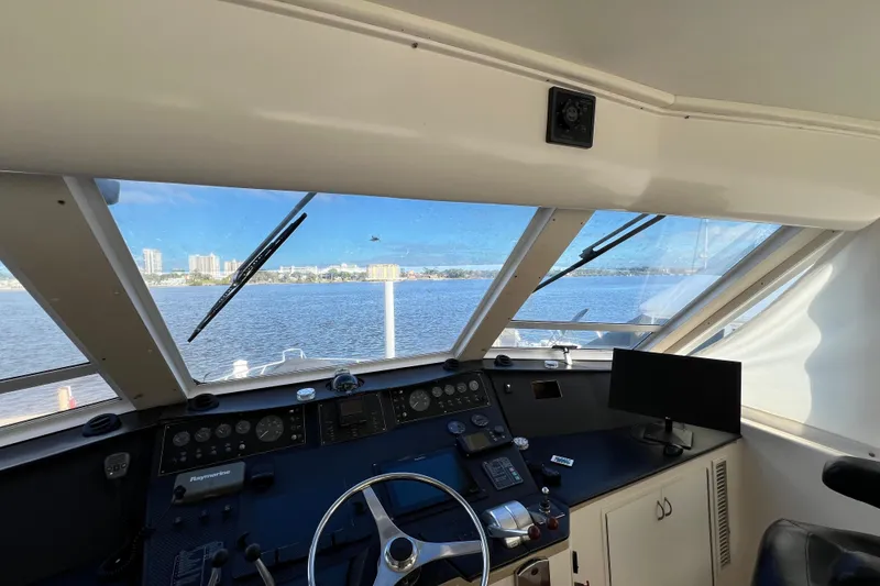 Slide: The Image of Interior view of 1999 Viking 60 CPMY yacht helm with waterfront cityscape. - 40