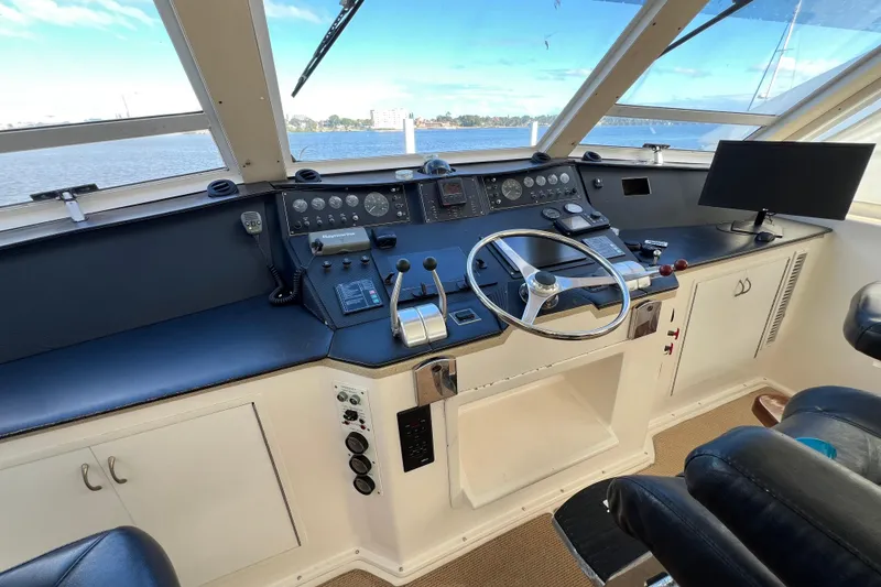 Slide: The Image of Helm of 1999 Viking 60 CPMY yacht with steering wheel and navigation controls. - 42