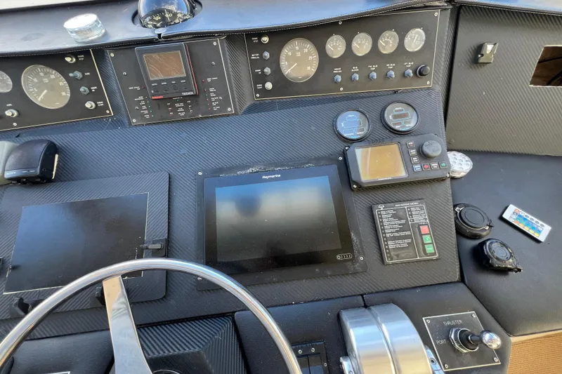 Slide: The Image of Control panel of a 1999 Viking 60 CPMY yacht with navigation instruments and steering wheel. - 44