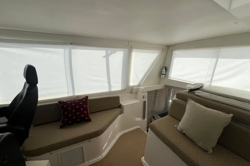 Slide: The Image of Interior of 1999 Viking 60 CPMY yacht with cushioned seating and decorative pillows. - 56