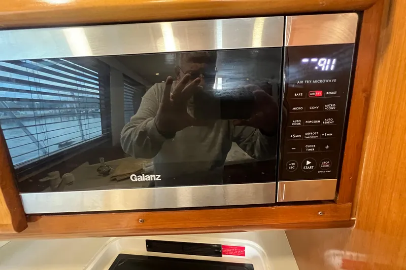 Slide: The Image of Galanz microwave in a 1999 Viking 60 CPMY yacht kitchen, showing control panel and reflection. - 74