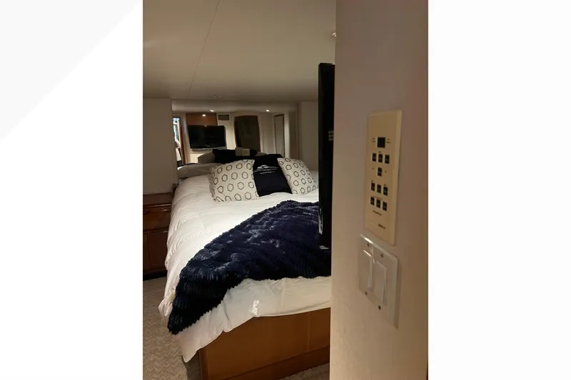 Slide: The Image of Luxurious bedroom interior of 1999 Viking 60 CPMY yacht with plush bedding and modern controls. - 96