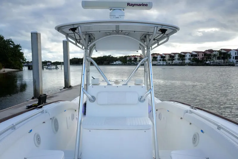 Slide: The Image of 2008 Buddy Davis 28 Center Console boat docked by waterfront homes under cloudy sky. - 14