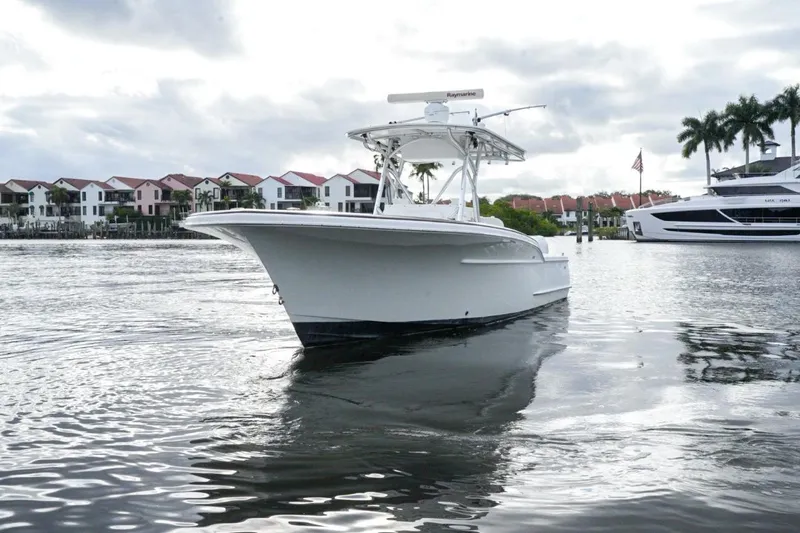 Slide: The Image of 2008 Buddy Davis 28 Center Console boat on calm water near waterfront homes. - 3