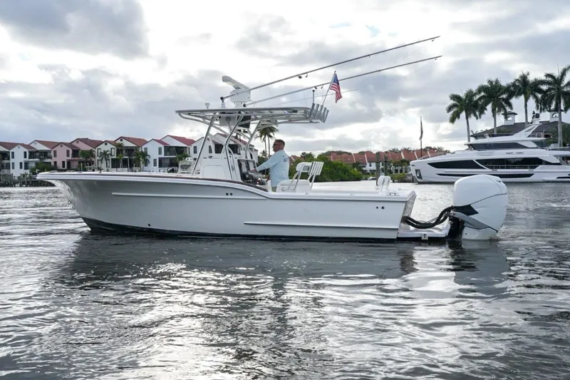 Slide: The Image of 2008 Buddy Davis 28 Center Console boat on water, with waterfront homes and palm trees. - 4