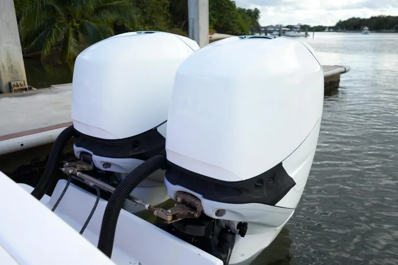 Slide: The Image of Twin outboard engines on a 2008 Buddy Davis 28 Center Console boat docked by water. - 7