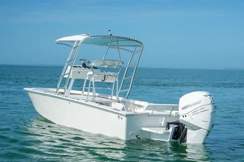 Slide: The Image of White 2016 Rambo 27 boat with Mercury engine on calm blue water. - 1