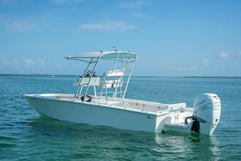 Slide: The Image of 2016 Rambo 27 boat on calm blue water under clear sky. - 13