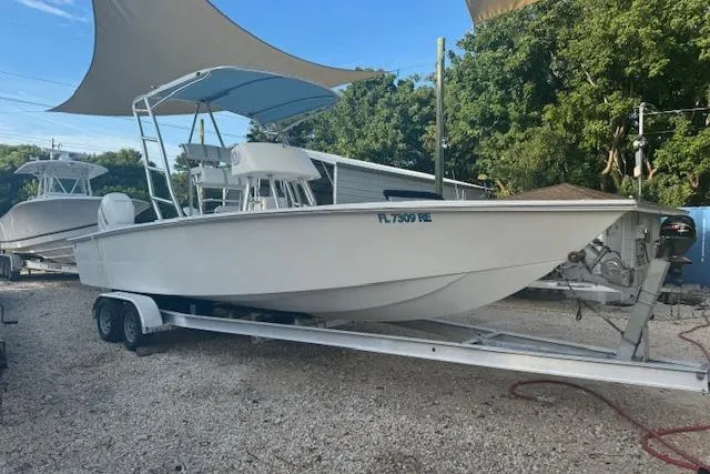 Slide: The Image of 2016 Rambo 27 boat on trailer under canopy, parked outdoors. - 17