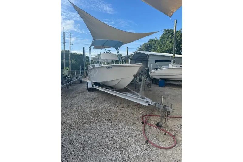 Slide: The Image of 2016 Rambo 27 boat on trailer under canopy, parked on gravel lot. - 18
