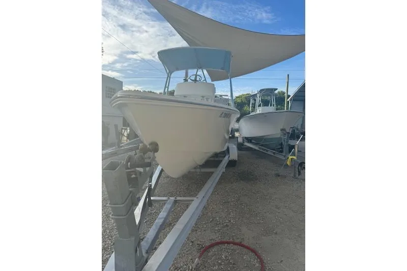 Slide: The Image of 2016 Rambo 27 boat on trailer under canopy, clear sky background. - 20