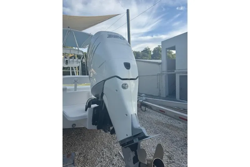 Slide: The Image of Outboard motor on a 2016 Rambo 27 boat, parked on gravel. - 23