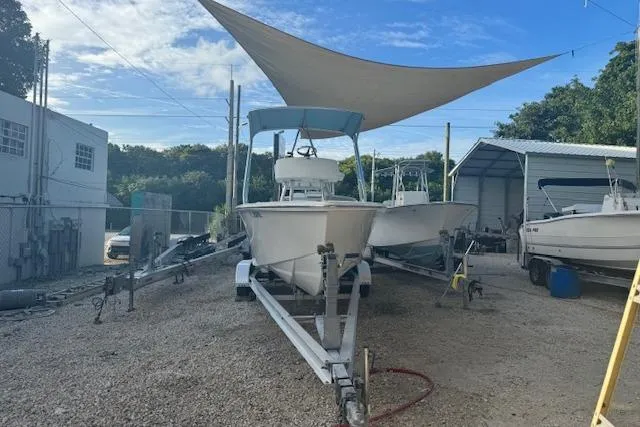 Slide: The Image of Boat on trailer under canopy, Rambo 27 model, 2016, parked in a gravel lot. - 25