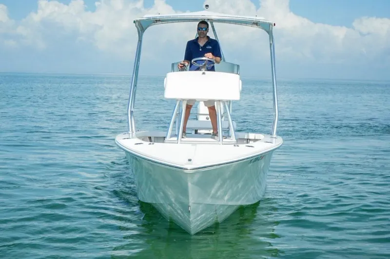 Slide: The Image of Man steering 2016 Rambo 27 boat on calm ocean waters. - 7