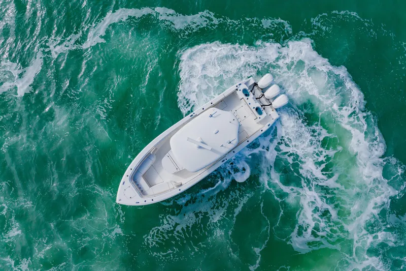 Slide: The Image of 2017 Cobia 344 Center Console boat navigating turquoise ocean waters. - 10