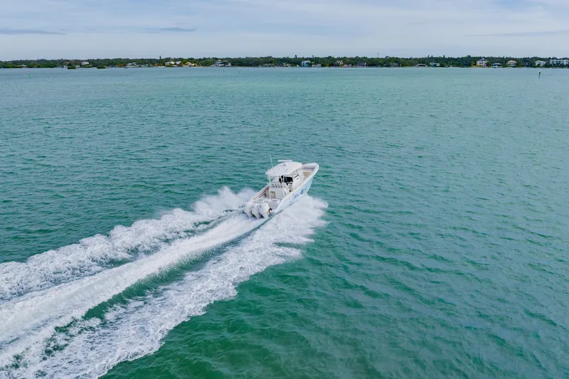Slide: The Image of 2017 Cobia 344 Center Console boat cruising on open water, creating a wake. - 11