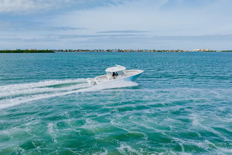 Slide: The Image of 2017 Cobia 344 Center Console cruising on turquoise ocean waters. - 17