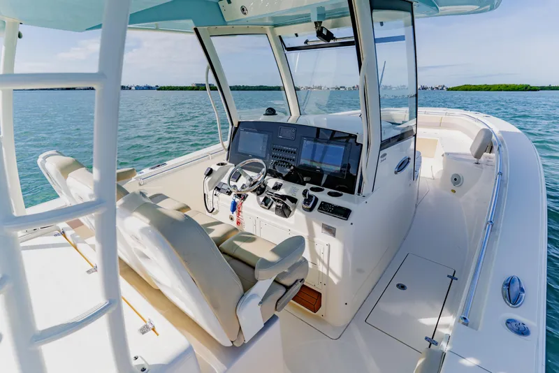 Slide: The Image of 2017 Cobia 344 Center Console boat interior with helm, steering wheel, and navigation equipment. - 33
