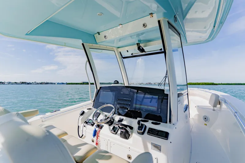 Slide: The Image of 2017 Cobia 344 Center Console boat interior with steering wheel and navigation system. - 34