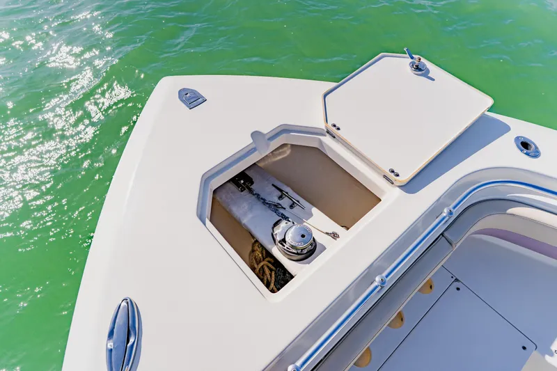 Slide: The Image of 2017 Cobia 344 Center Console boat anchor compartment on turquoise water. - 41