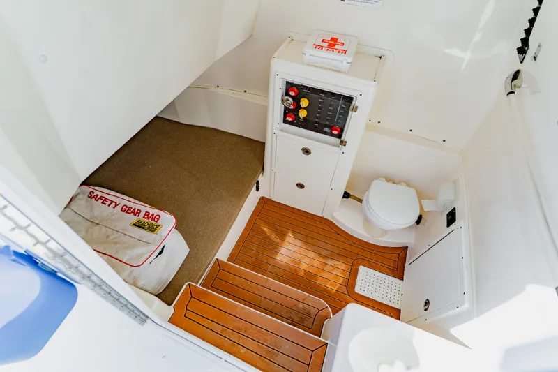 Slide: The Image of 2017 Cobia 344 Center Console interior with safety gear bag and wooden flooring. - 44